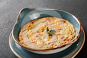 Breakfast, Omelette with vegetables and herbs on plate over black table surface. Healthy food