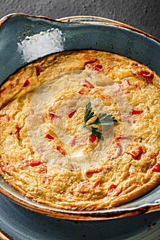 Breakfast, Omelette with vegetables and herbs on plate over black table surface. Healthy food