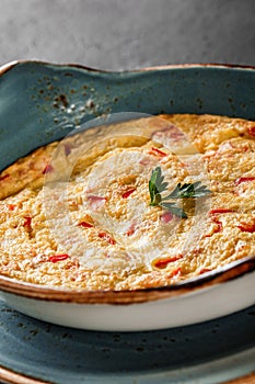 Breakfast, Omelette with vegetables and herbs on plate over black table surface. Healthy food