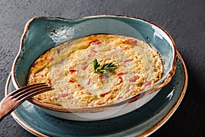 Breakfast, Omelette with vegetables and herbs on plate over black table surface. Healthy food