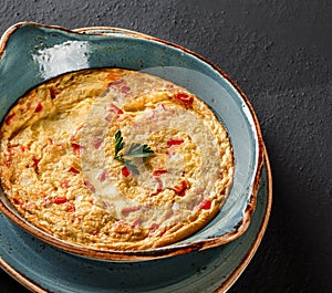 Breakfast, Omelette with vegetables and herbs on plate over black table surface. Healthy food