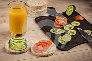 Breakfast: orange juice with small loafs and vegetables/breakfast: orange juice with small loafs and vegetables on a wooden table