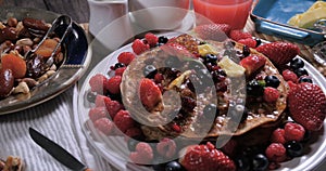 A breakfast of pancakes with berries and dry fruits