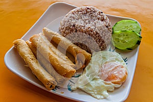 Breakfast in Philippines - rice with fried rolls (lumpia) and e