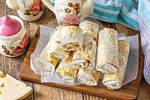 Breakfast, picnic, lunch or snack concept. Lavash roll with cottage cheese, cheese and spinach.