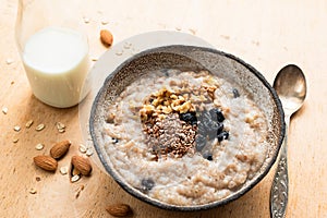 Breakfast porridge oats in bowl on wooden table