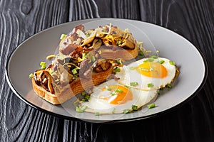 Breakfast portion of fried toast with shiitake mushrooms and cheese served with eggs and green onions close-up on a plate.