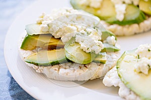 Breakfast of puffed wheat toast with avocado and fresh cheese