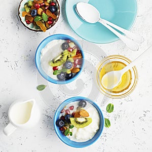 Breakfast, rice porridge or natural yoghurt with assorted berries, fruits and nuts: kiwi, pomegranate, blueberries