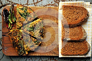 Breakfast with rustic frittata and bread on a wooden board