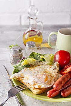 Breakfast sandwich with sausage, coffee and tomato