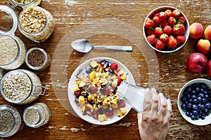 Breakfast scene hand pouring milk on muesli healthy lifestyle organic nutrition