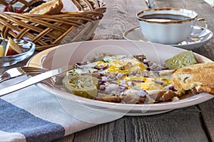 Breakfast with Scrambled eggs, bacon, pickles,toasted bread, butter nad coffee.