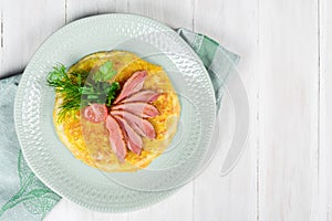 Breakfast of scrambled eggs and meat with tomatoes