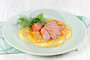 Breakfast of scrambled eggs and meat with tomatoes