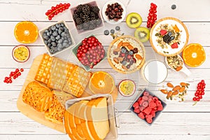 Breakfast Served in the morning with Butter bread and corn flakes Whole grains and raisins with milk in cups and Strawberry, Blueb