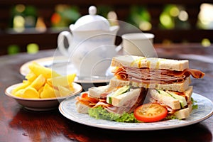 a breakfast set with clubhouse sandwich and a cup of tea