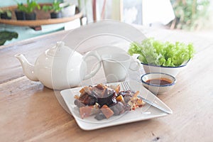 The breakfast set features white teapot and teacups with roasted pork