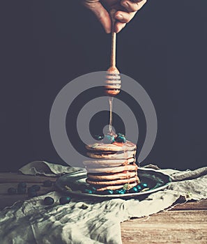 Breakfast set. Thin crepes with red caviar on rustic metal plate, fresh thyme and vintage dinnerware over a rough wood