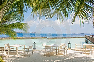 Breakfast setup with tables and chairs at the tropical beach