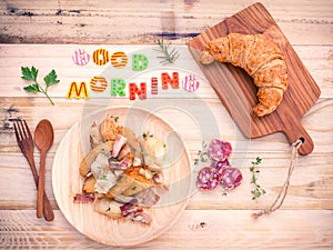 Breakfast setup on wooden table with colourful Good Morning wor