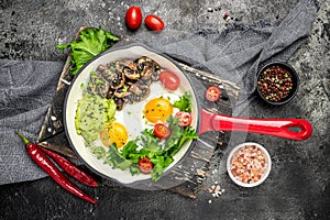 Breakfast skillet pan of fried egg, avocado and mushrooms. Ketogenic diet. Low carb high fat breakfast. Healthy food concept.