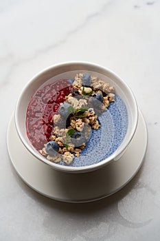 Breakfast smoothie bowl with granola on white background