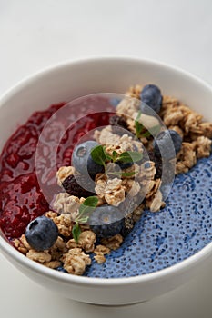 Breakfast smoothie bowl with granola on white background