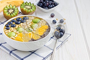 Breakfast smoothie bowl topped with berries, fruits, nuts and seeds