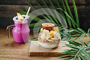 Breakfast Smoothie and Muesli with yoghurt and tropical fruit at brown background