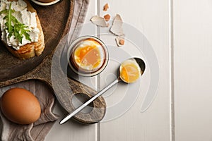 Breakfast with soft boiled egg served on white wooden table, flat lay. Space for text