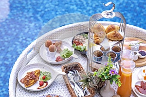 Breakfast in swimming pool, floating breakfast in villa resort. relaxing in calm pool water, healthy breakfast and tropical fruit