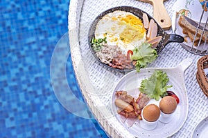 Breakfast in swimming pool, floating breakfast in villa resort. Relaxing in calm pool water, healthy breakfast and tropical fruit