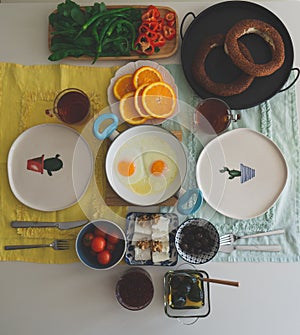 Breakfast table with bagels, oranges and other fresh vegetables