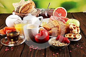 Breakfast on table with bread buns, croissants, coffe and juice on valentines day