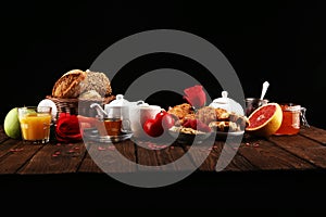 Breakfast on table with bread buns, croissants, coffe and juice on valentines day