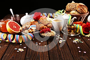 Breakfast on table with bread buns, croissants, coffe and juice on carnival