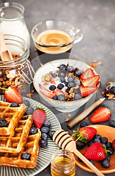 Breakfast table with cereal granola, milk, fresh berries, coffee