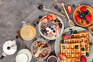 Breakfast table with cereal granola, milk, fresh berries, coffee