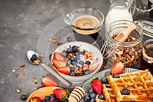 Breakfast table with cereal granola, milk, fresh berries, coffee