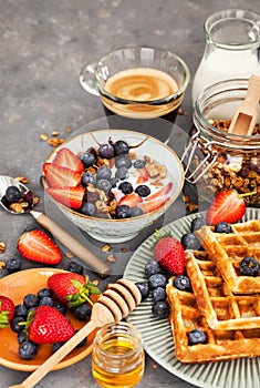 Breakfast table with cereal granola, milk, fresh berries, coffee