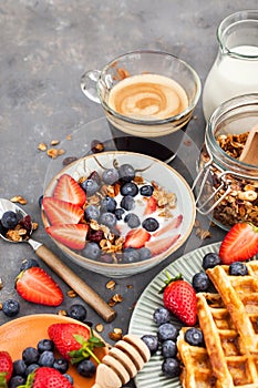 Breakfast table with cereal granola, milk, fresh berries, coffee