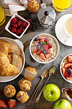 Breakfast table with oatmeal porridge, croissants and muffins