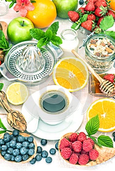 Breakfast table setting with coffee, croissants, granola, honey.