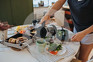 Breakfast table and woman poring coffee.