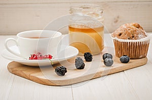 Breakfast: tea with fresh berries, cake and honey/healthy breakfast: tea with fresh berries, cake and honey. Selective focus