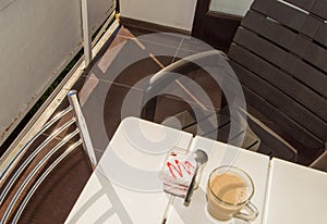 Breakfast on the terrace of the balcony at home or in the hotel, creamy yogurt with berry jam and latte coffee