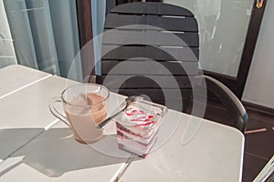 Breakfast on the terrace of the balcony at home or in the hotel, creamy yogurt with berry jam and latte coffee