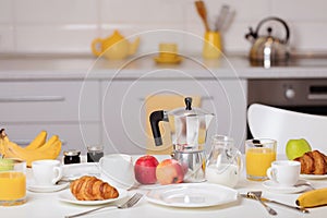 Breakfast time. Croissants and orange juice, jam and honey. Coffee with cream or milk. Fruits - bananas, red and green apples