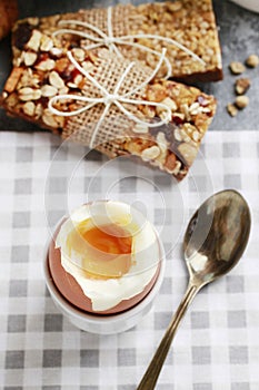 Breakfast time: soft-boiled egg, french croissants, muesli bars, milk